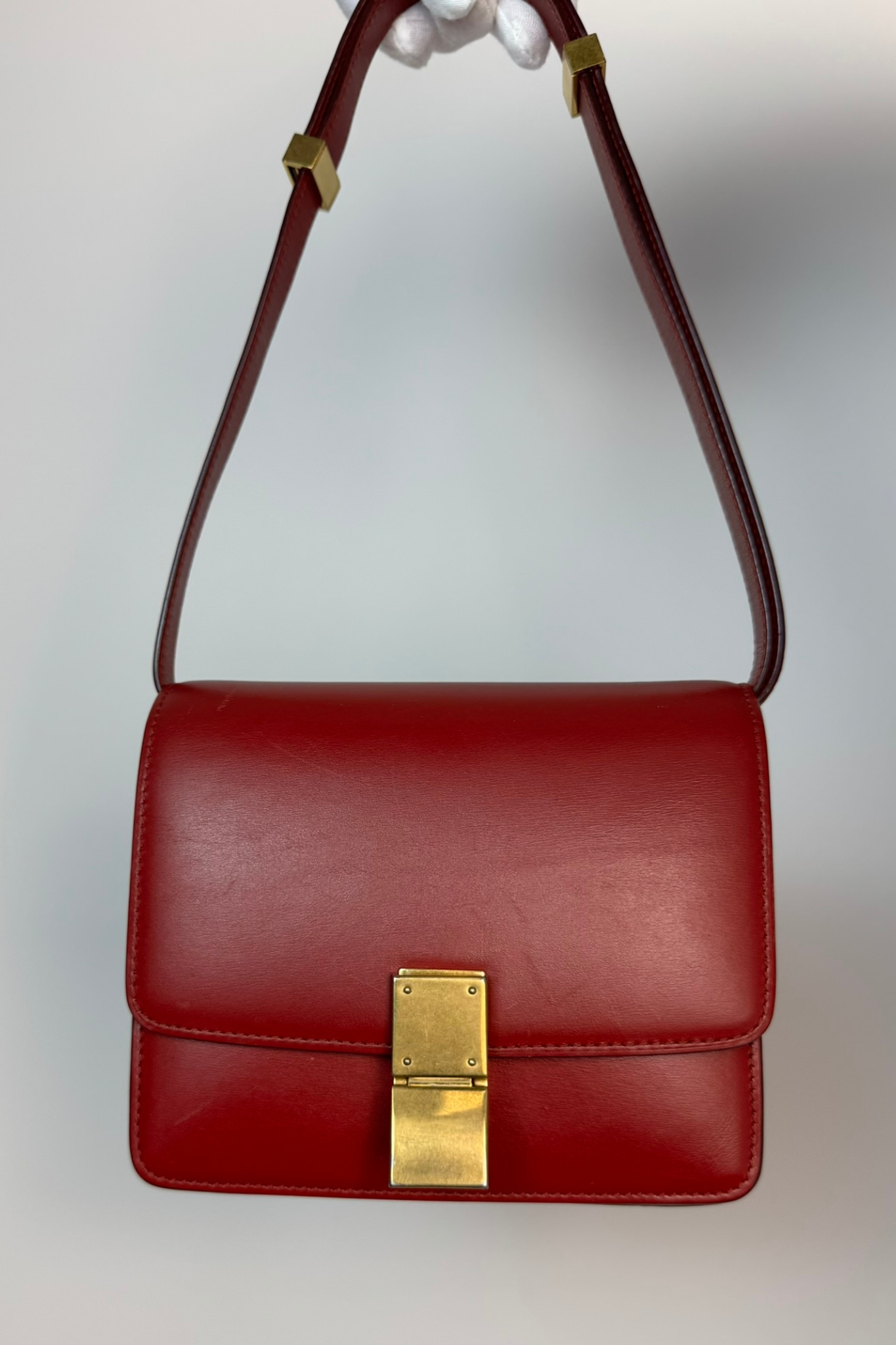 Red handbag with a gold clasp on a light gray background